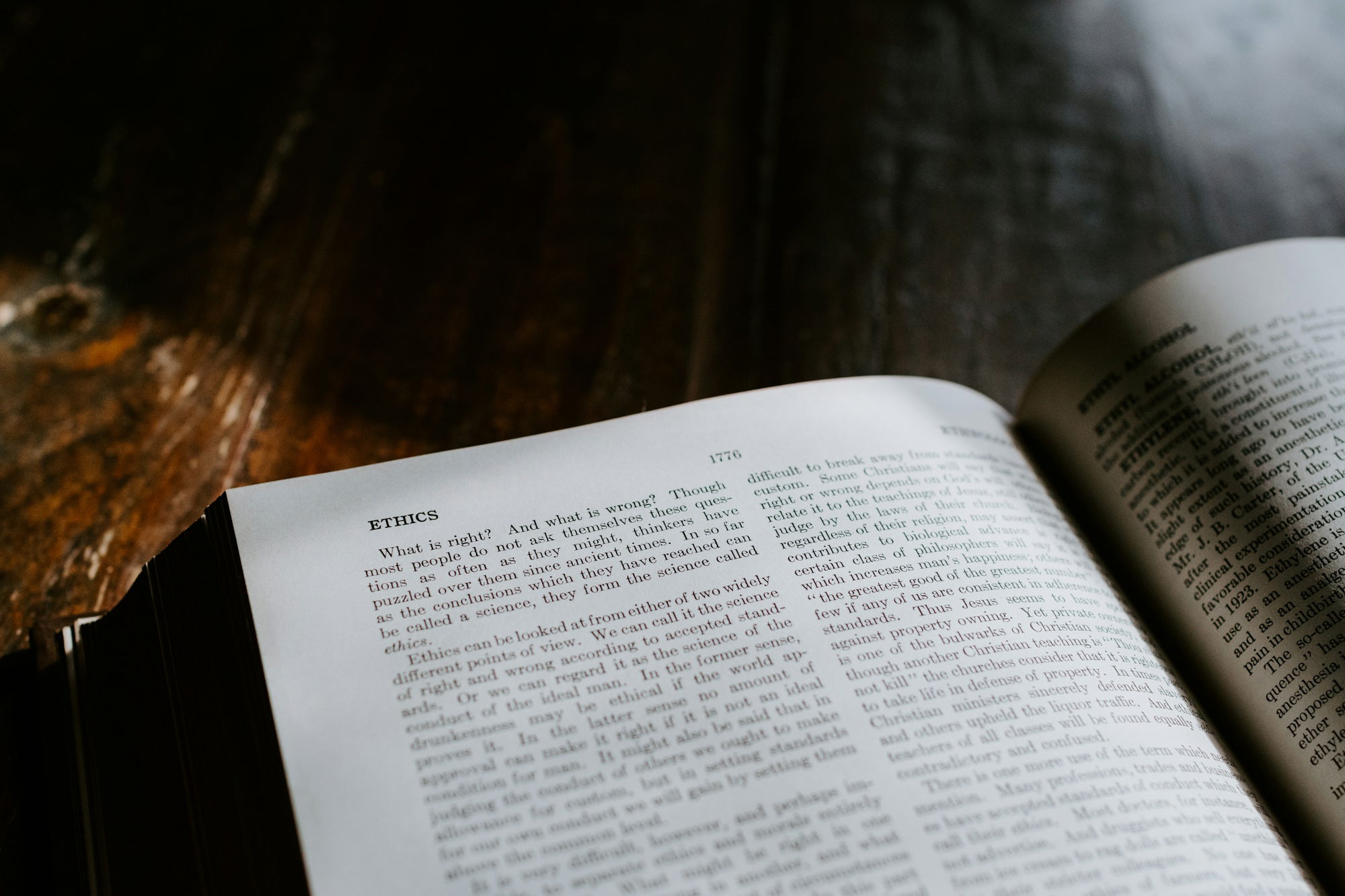 an-open-book-sitting-on-top-of-a-wooden-table.jpg an open book sitting on top of a wooden table